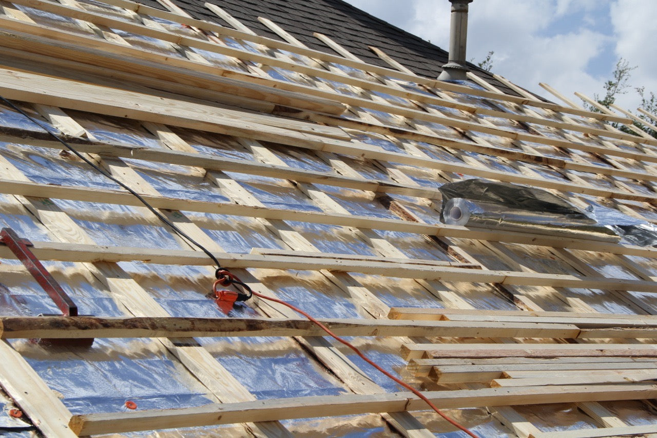 Construction of a double batten roof system over RoofingFoil single sided solid foil insulation with visible blue sky in the background